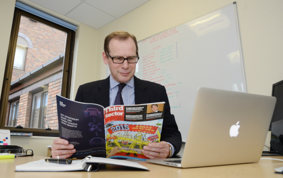 CEO, Mark Hollingsworth in his office reading a magazine