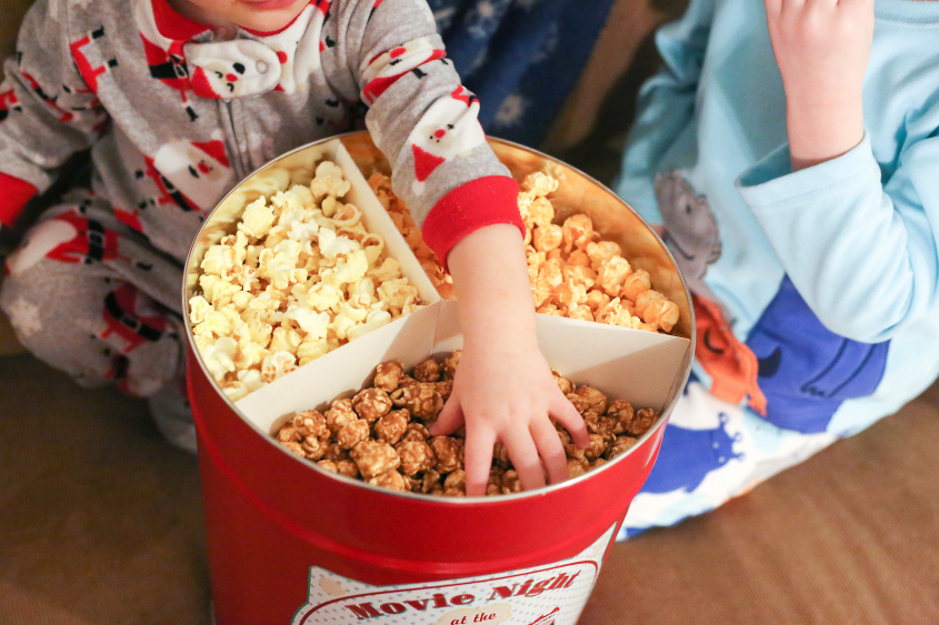 Child eating popcorn whilst watching a movie