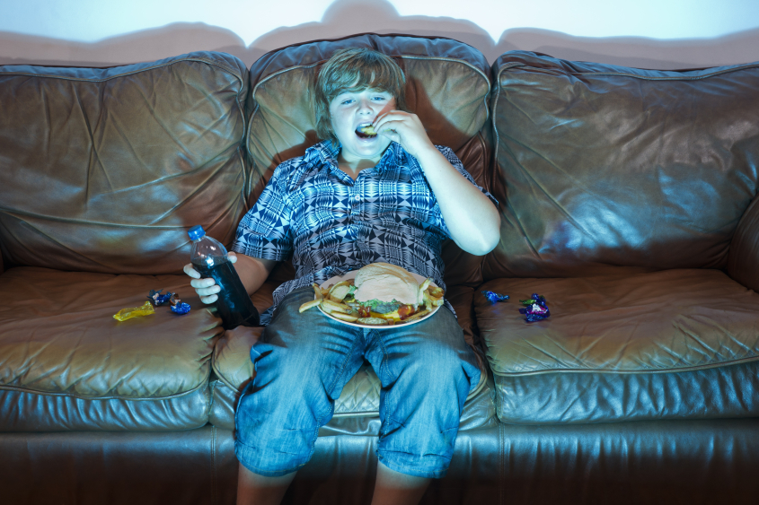 Boy watching TV eating dinner